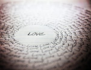 the word love written on a lined piece of school paper in ink wi
