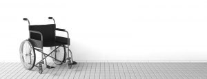 Black disability wheelchair near clean white wall